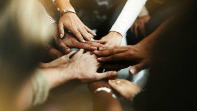 closeup diverse people joining their hands