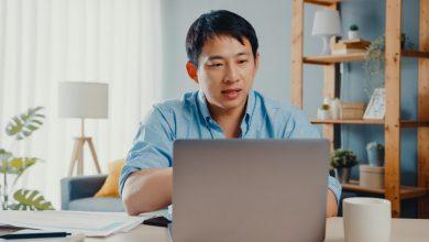 young asia businessman using laptop talk colleagues about plan video call while smart working from home