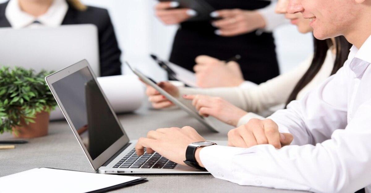 smiling businessman s hand using laptop sitting with his colleague desk 23 2148073303 3