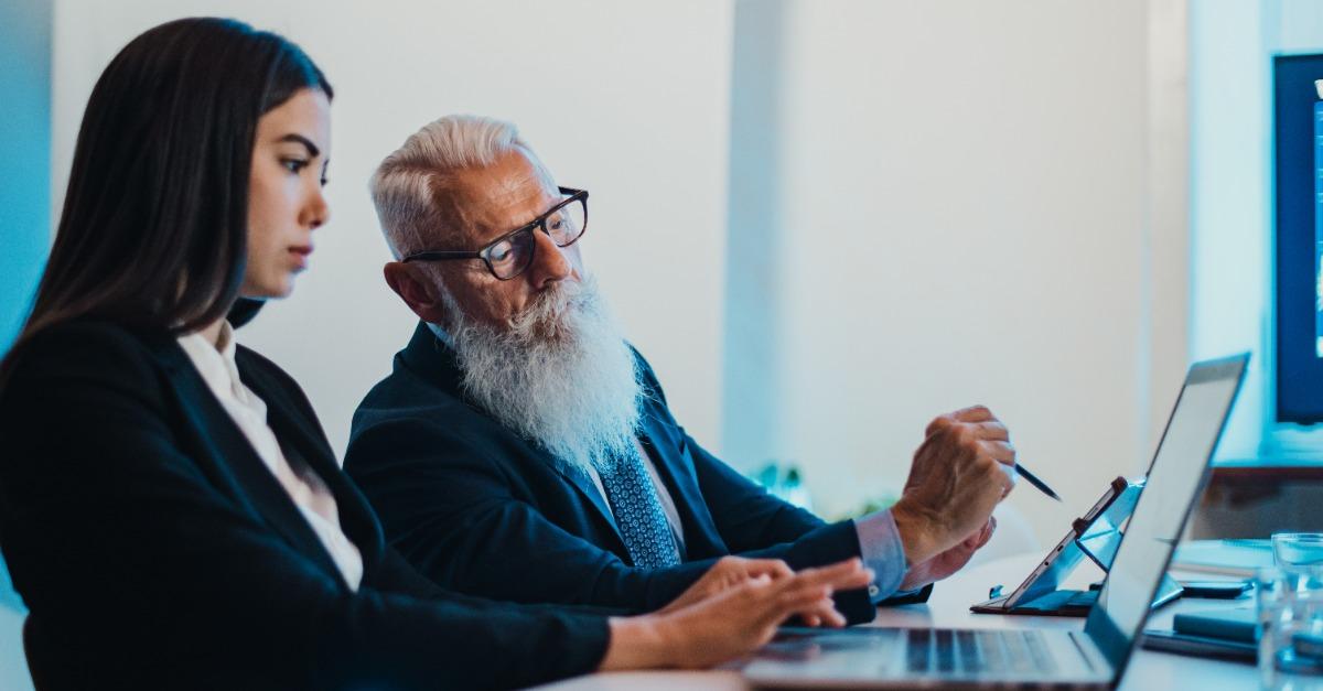 Senior businessman helping young colleague