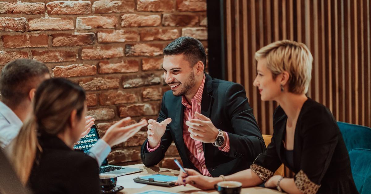 Happy businesspeople smiling cheerfully during a meeting in a coffee shop