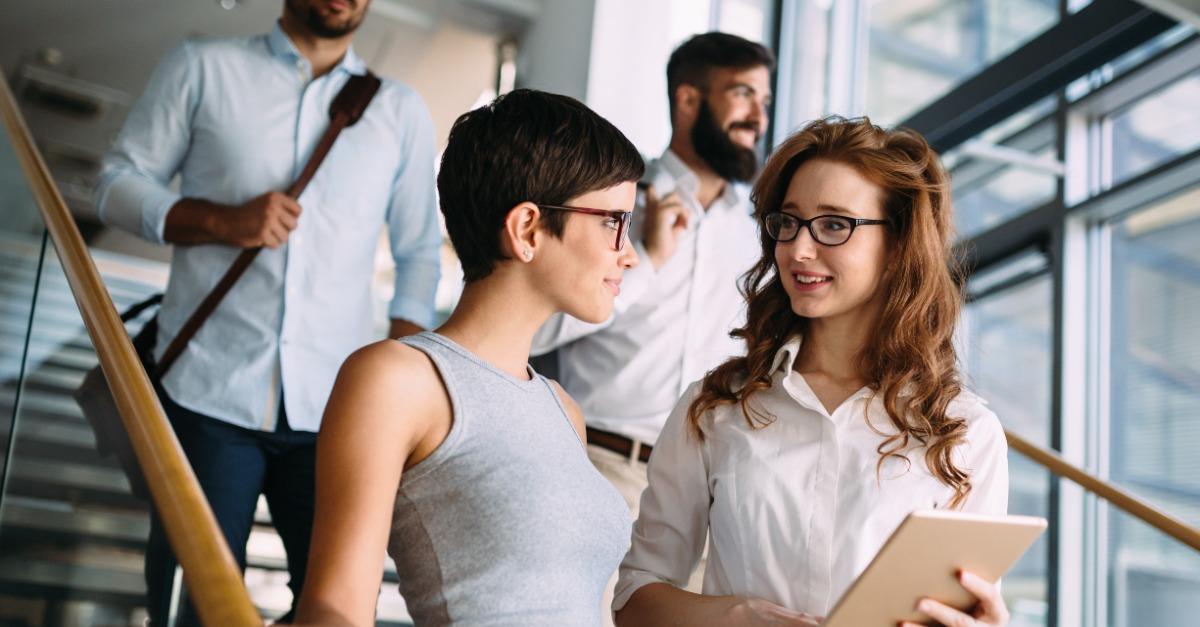 Portrait of two young attractive businesswomen talking on break