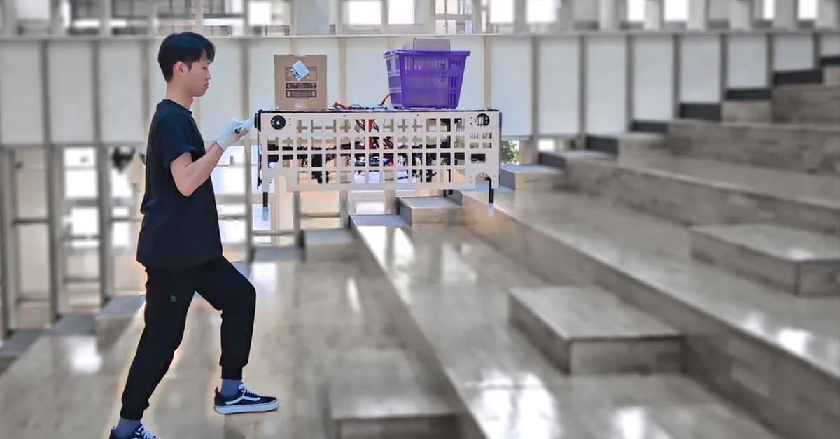 The Palletrone flies at roughly chest height and keeps the upper cargo platform level while a human operator pushes it around