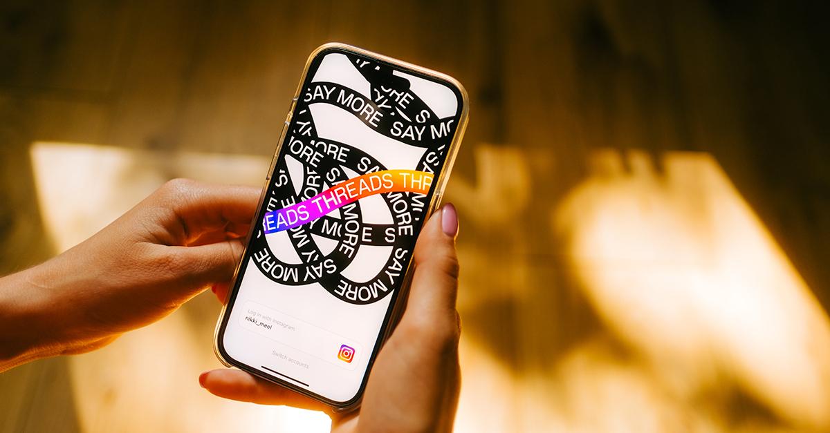 Threads app logo on iPhone screen in hands 123rf