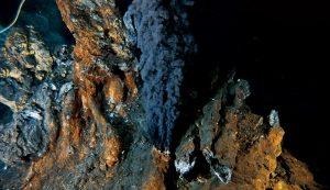 海底的熱液噴口會冒出黑煙，這些黑煙是在超熱的噴口水遇到冰冷海水時形成的。科學家認為這些噴口可能是生命起源的地點，因為它們提供了熱量、礦物質以及早期生命可用來形成和生長的化學能量。（圖／Rutgers University／Richard Lutz）