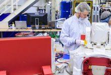 在甘迺迪太空中心，林肯實驗室（Lincoln Laboratory）人員 Justin Dunbeck（左）與 Steven Constantine 正在拆封並檢查 NASA 阿提米絲二號（Artemis II）登月任務所使用的光學通訊系統酬載。（圖／Glenn Benson/NASAGlenn Benson/NASA）
