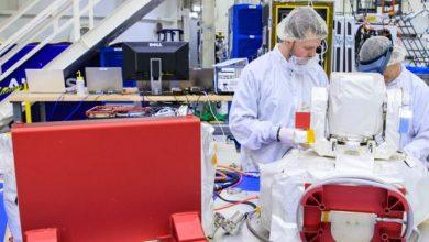 在甘迺迪太空中心，林肯實驗室（Lincoln Laboratory）人員 Justin Dunbeck（左）與 Steven Constantine 正在拆封並檢查 NASA 阿提米絲二號（Artemis II）登月任務所使用的光學通訊系統酬載。（圖／Glenn Benson/NASAGlenn Benson/NASA）