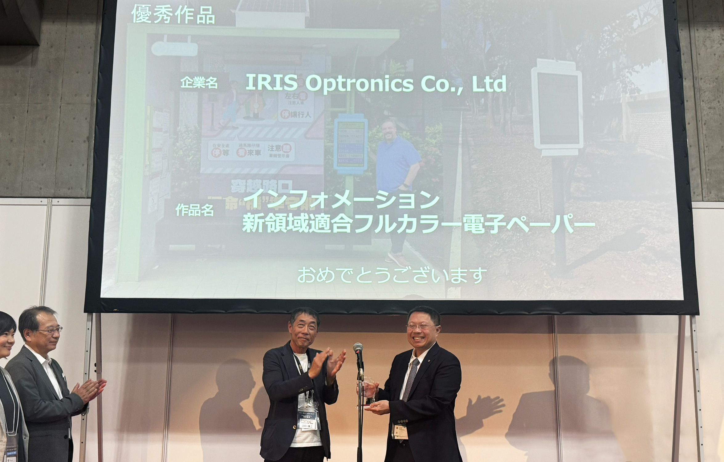 虹彩光電榮獲由日本數位電子看板聯盟（DSC）主辦之2026日本數位電子看板優異獎，成為獎項成立以來第一個海外獲獎企業。( 圖左：DSC常務理事江口靖二、圖右：虹彩光電董事長廖奇璋 )