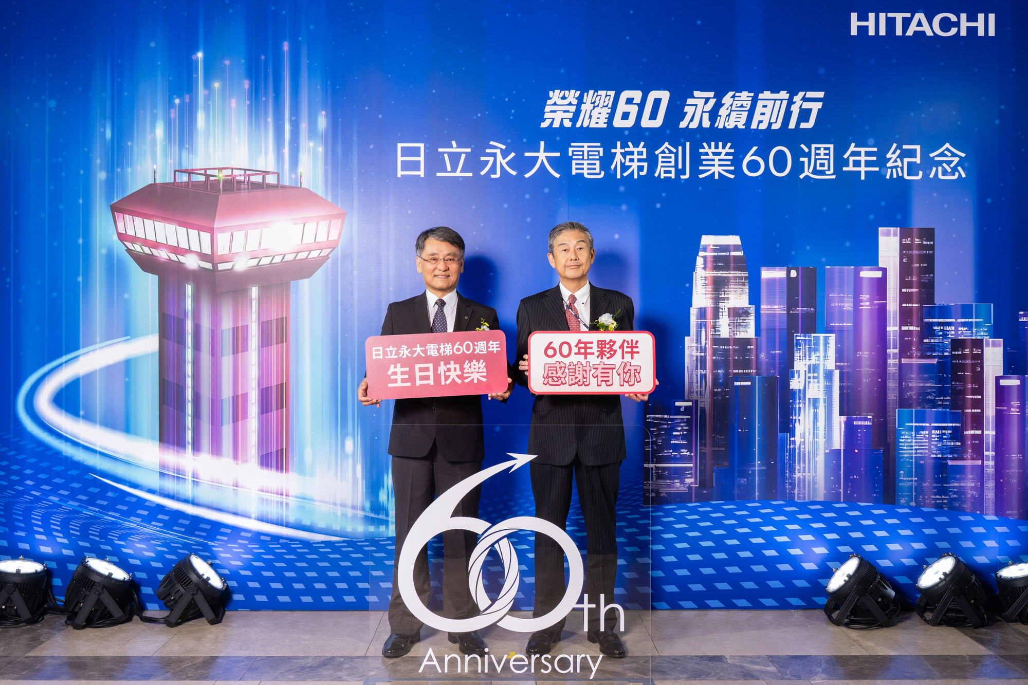 日立永大電梯董事長小口辰廣(右)、總經理沈裕舜(左)在創業60週年紀念儀式上，宣布啟動「數位轉型」與「綠色轉型」雙軸轉型策略。 （圖／日立永大電梯提供）