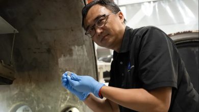 NASA蘭利研究中心SPEARS計畫測試與研究負責人Yi Lin，手持一顆剛完成熱真空測試的小型鈕扣型電池。（圖／NASA／Ryan Hi）