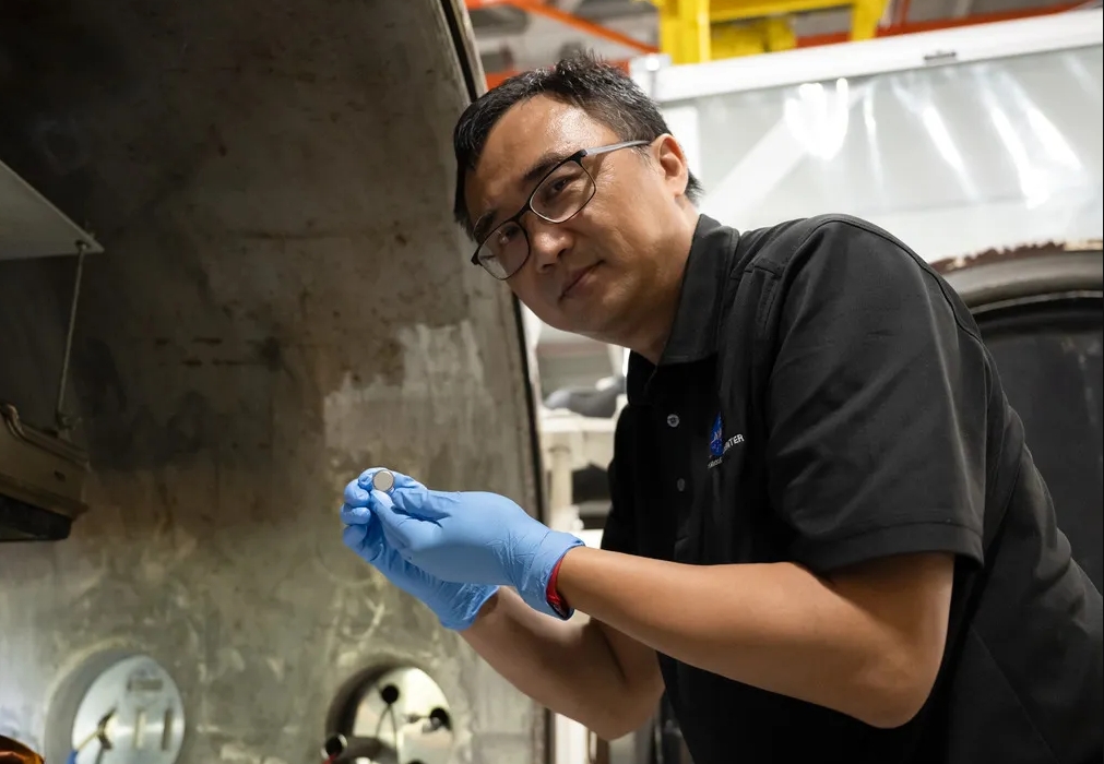 NASA研發新型電池 為人類重返月球提供電力 1 NASA蘭利研究中心SPEARS計畫測試與研究負責人Yi Lin,手持一顆剛完成熱真空測試的小型鈕扣型電池。(圖/NASA/Ryan Hi)